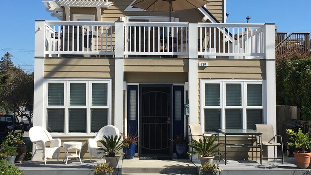 A two-story house with a balcony, a covered patio, and a garage. - Clean, Newly Remodeled Home Steps to  Beach, HOT TUB, LARGE deck  w/ocean peek (Santa Cruz)