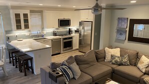 A modern kitchen with a central island, stainless steel appliances, and a ceiling fan. - Clean, Newly Remodeled Home Steps to  Beach, HOT TUB, LARGE deck  w/ocean peek (Santa Cruz)