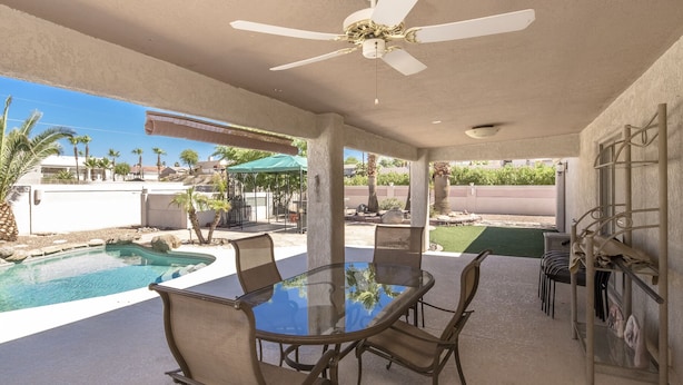A covered patio with a pool, outdoor seating, and a ceiling fan. -  Executive style pool home with easy boat parking, Small dogs OK. (Lake Havasu City)
