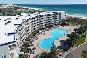 Un hôtel doté de nombreux balcons, d’une piscine et offrant une vue sur la plage.