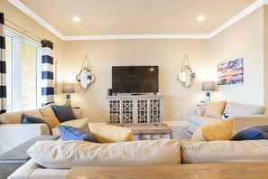 A living room with a sofa set, a television, and a cabinet with glass doors.