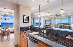 Enjoy ocean views from the dining area and kitchen, featuring a large window and pendant lights.