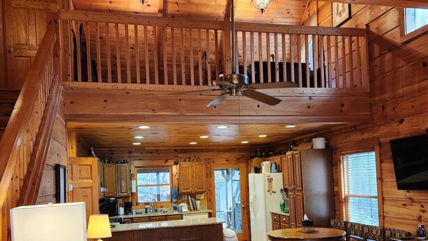 A spacious wooden cabin with a central living area featuring a sofa set, a dining table, and a kitchen in the background. - 'Just a Step Away' - a Secluded Cabin on Stover Creek w/Fiber Wi-Fi & Hot Tub (Ellijay)