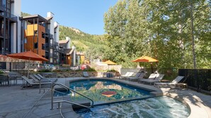 Et poolområde med liggestole, parasoller og jacuzzi.