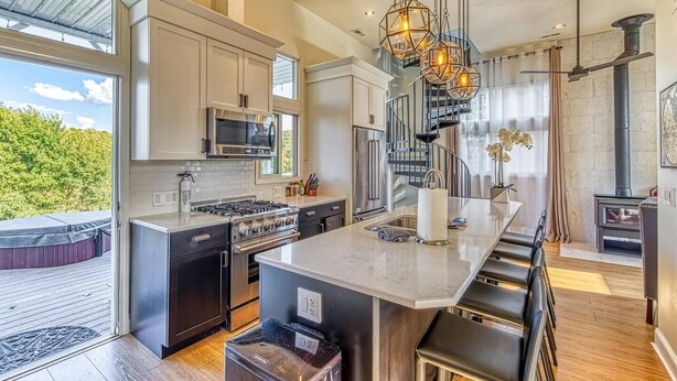 A modern kitchen with a large island, stainless steel appliances, and a view of the outdoors. - Smart Home, direct Beach Dunes Nat’l Park access, Hot Tub, luxury amenities (Miller Beach)