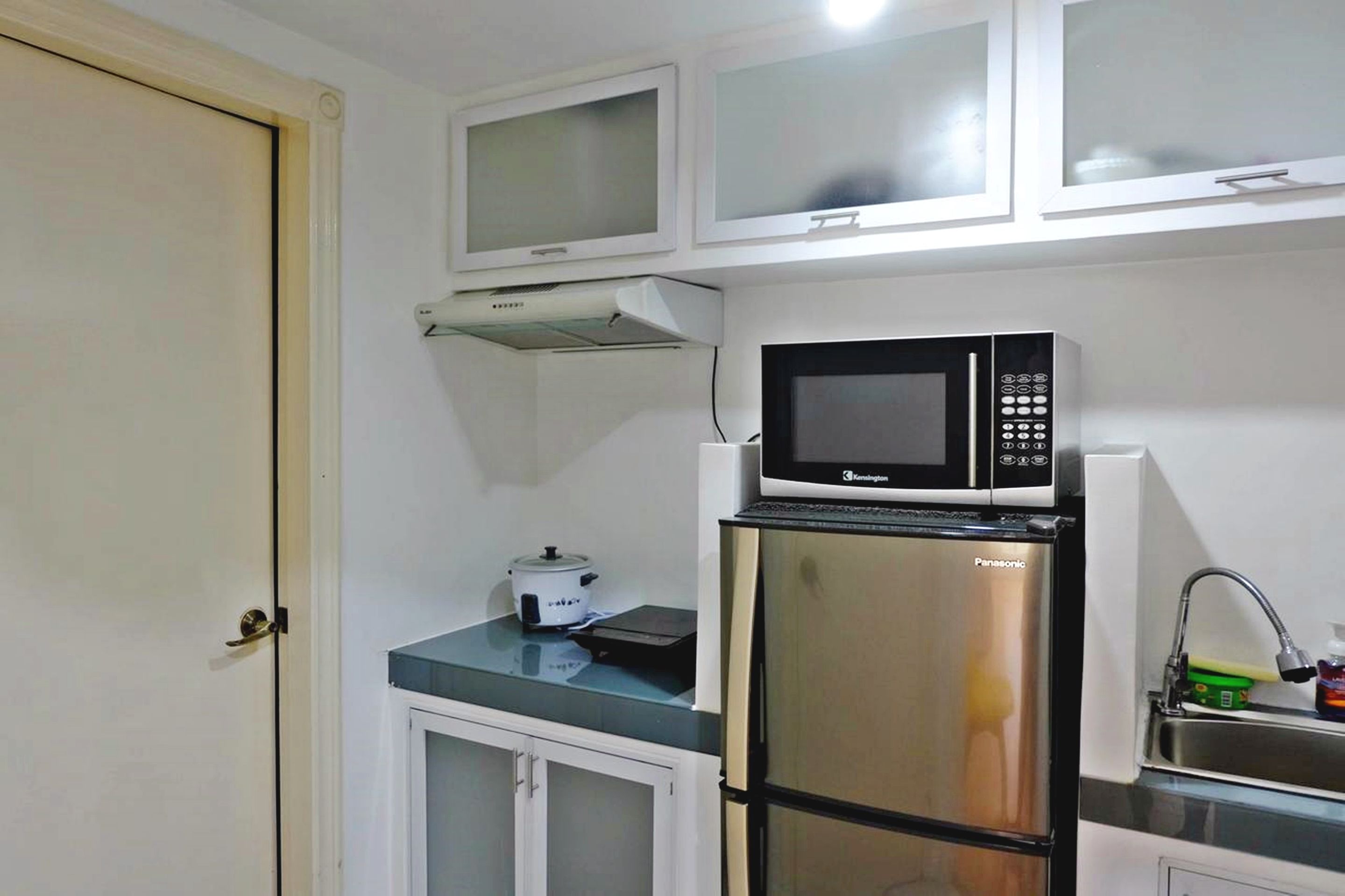 A compact kitchen with a microwave, a refrigerator, and a small countertop.
