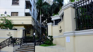 A building entrance with a staircase, a security camera, and a sign that reads "Forbeswood Heights." - Forbeswood Heights 2BR by Stays PH (Taguig)