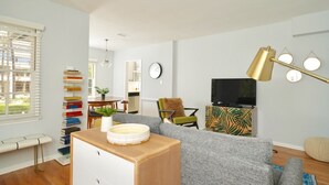 A modern living room with a sofa, a coffee table, a TV, and a bookshelf. - City Haven (Burbank)