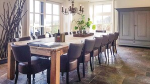 A dining area with a wooden table, black chairs, a chandelier, and a large window. - Pet friendly home in Leende with house a panoramic view (Leende)