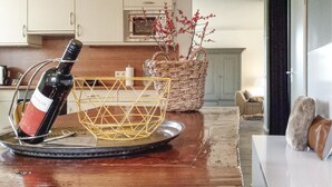 A kitchen with a wine bottle on a tray, a woven basket, and a vase with red berries. - Pet friendly home in Leende with house a panoramic view (Leende)