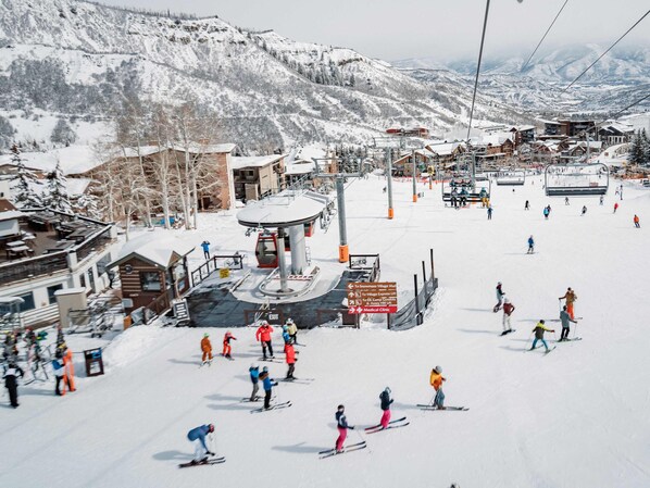A ski resort with a chairlift, ski slopes, and buildings. - Aspenwood L3 - Ski, Soak, Relax | Cozy Mountain Stay, Walk to Slopes (Snowmass Village)
