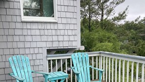 A wooden deck with two turquoise Adirondack chairs and a small table. - Beach Oasis. 2 Mins to Priv Beach&4X4 beach.Hottub.Foosball.Close to shop/dining (Corolla)