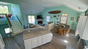 A spacious kitchen with a granite countertop, white cabinets, and a dining area with a table and chairs. - Beach Oasis. 2 Mins to Priv Beach&4X4 beach.Hottub.Foosball.Close to shop/dining (Corolla)