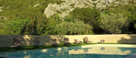 Piscine extérieure en saison, parasols, chaises longues