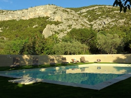 Une piscine dotée de chaises longues et offrant une vue sur un paysage montagneux.
