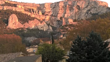 A mountainous landscape with rocky cliffs and a village below.