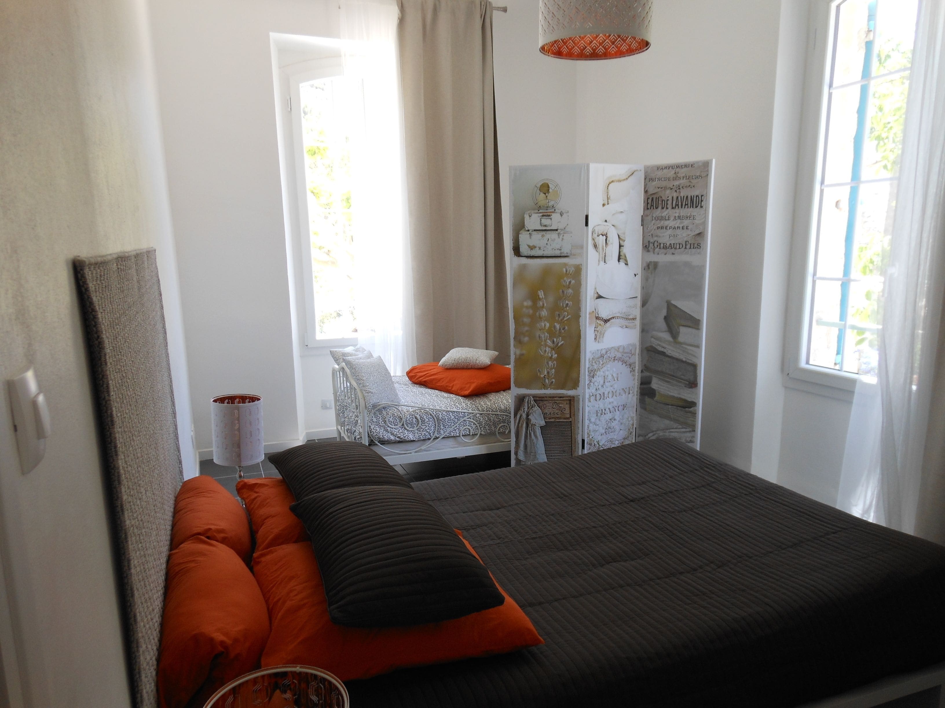 A bedroom with a bed, a bedside table, a window, and a wardrobe.