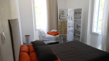 A bedroom with a bed, a bedside table, a window, and a wardrobe.