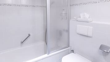 A modern bathroom with a glass-enclosed shower, a toilet, and a paper towel dispenser.