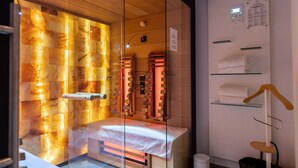 Un baño moderno con separador de vidrio, suelo con calefacción y un perchero para toallas.