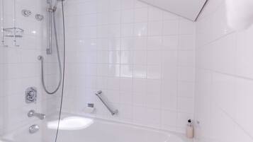 Een moderne badkamer met een douche met glazen wand, een badkuip en witte betegelde wanden.