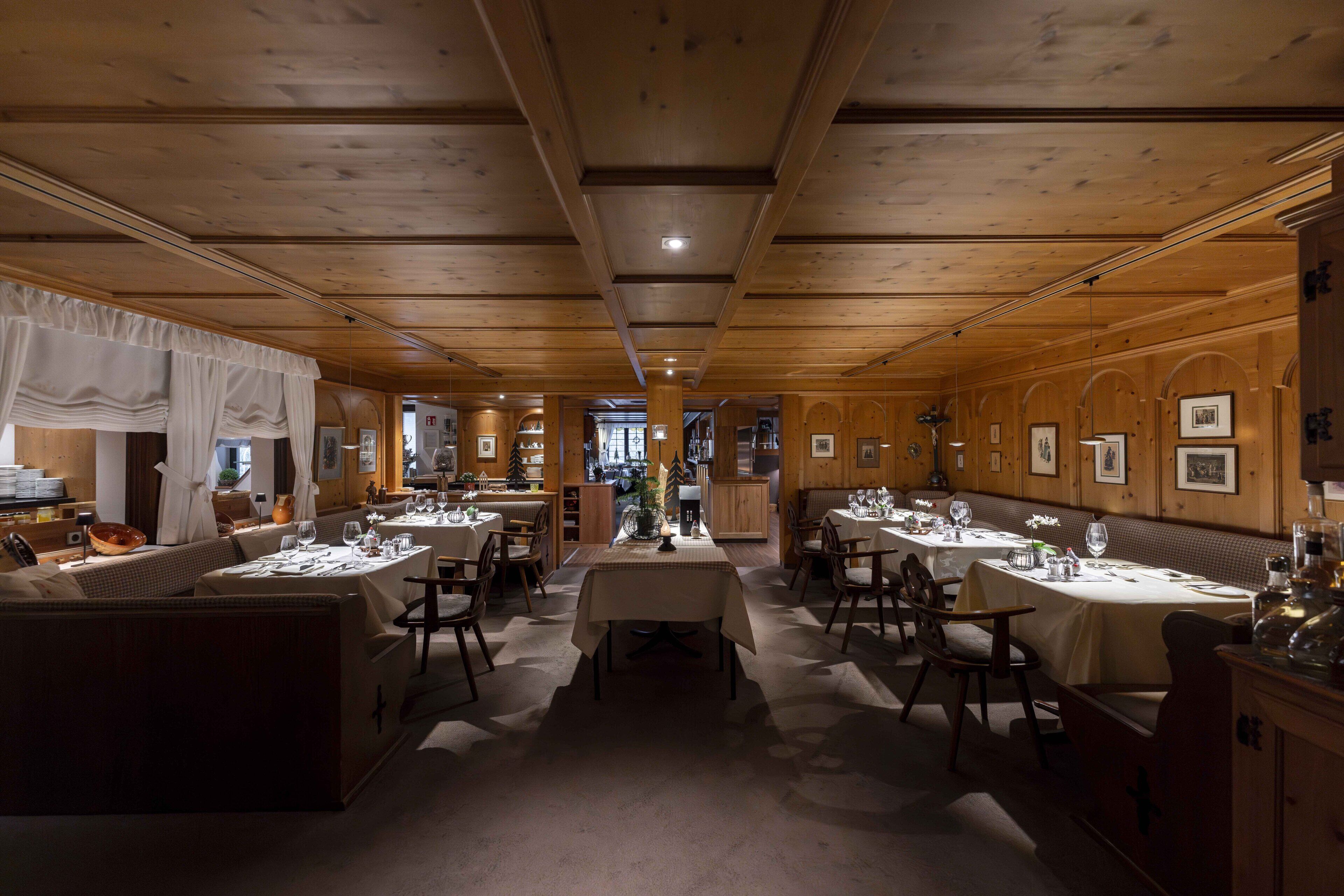 Un restaurant au décor intérieur en bois, doté de nombreuses tables et de plusieurs banquettes.