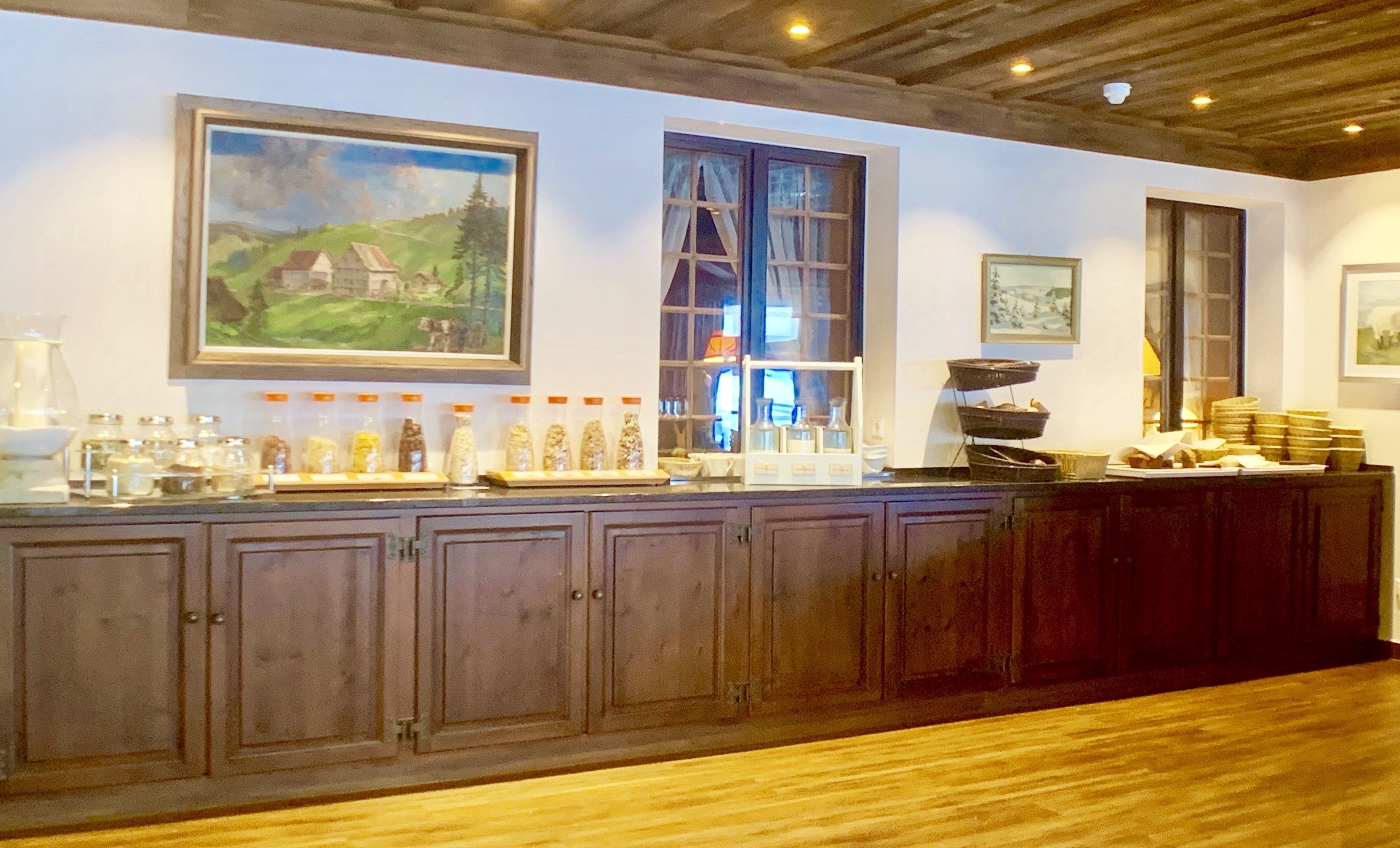 Eine Bar mit Holzausstattung, einer Theke mit Gläsern und gerahmten Bildern an der Wand.