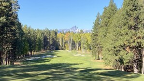 Un parcours de golf offrant une vue dégagée sur une montagne en arrière-plan.