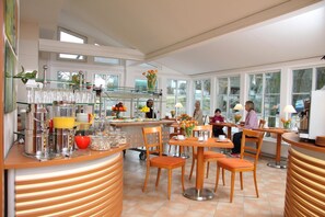 A modern breakfast area with a counter, seating, and a view of the outdoors.