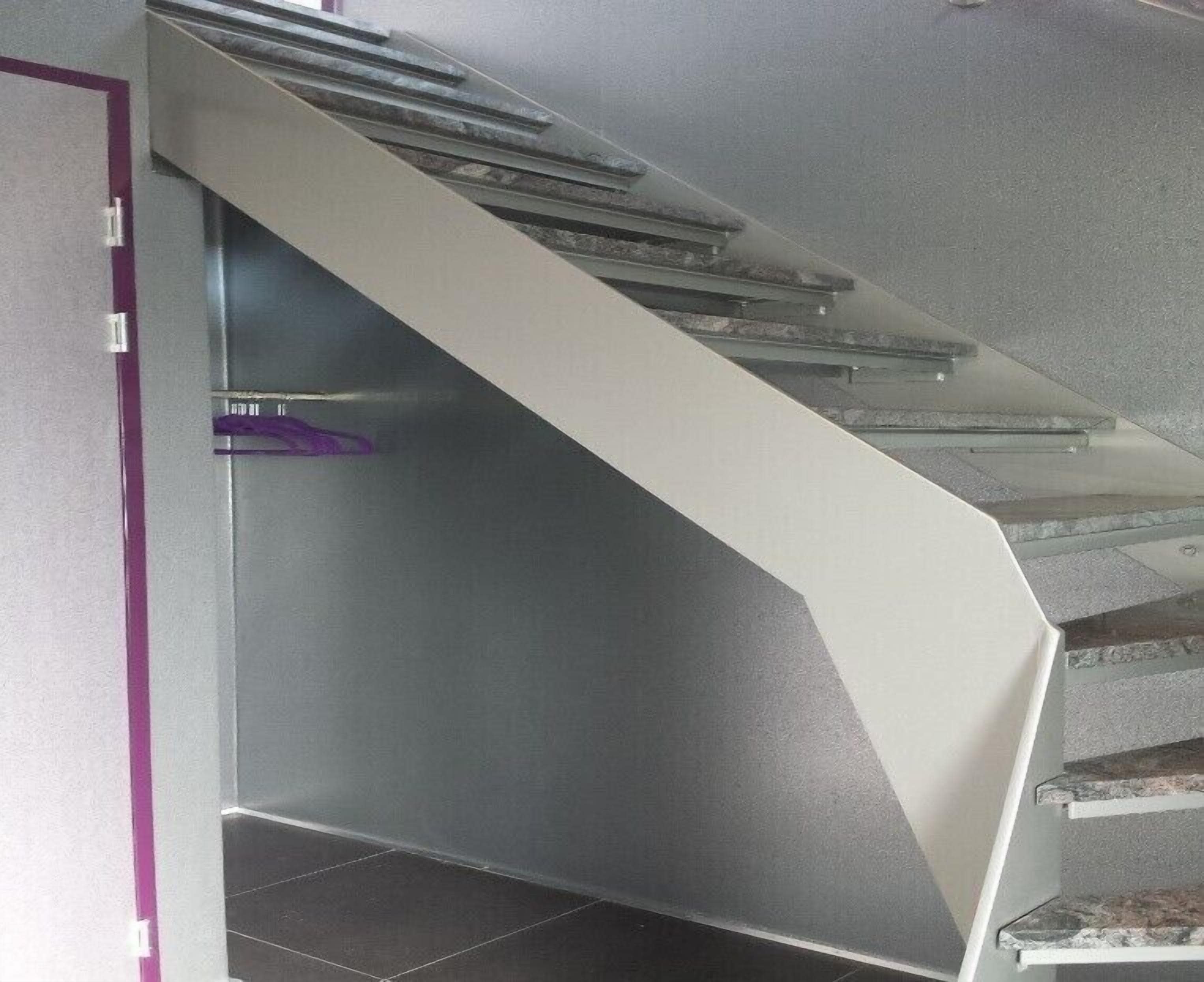 A modern staircase with glass railings and a metallic handrail.