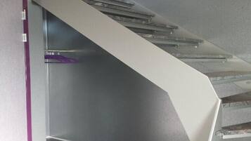 A modern staircase with glass railings and a metallic handrail.