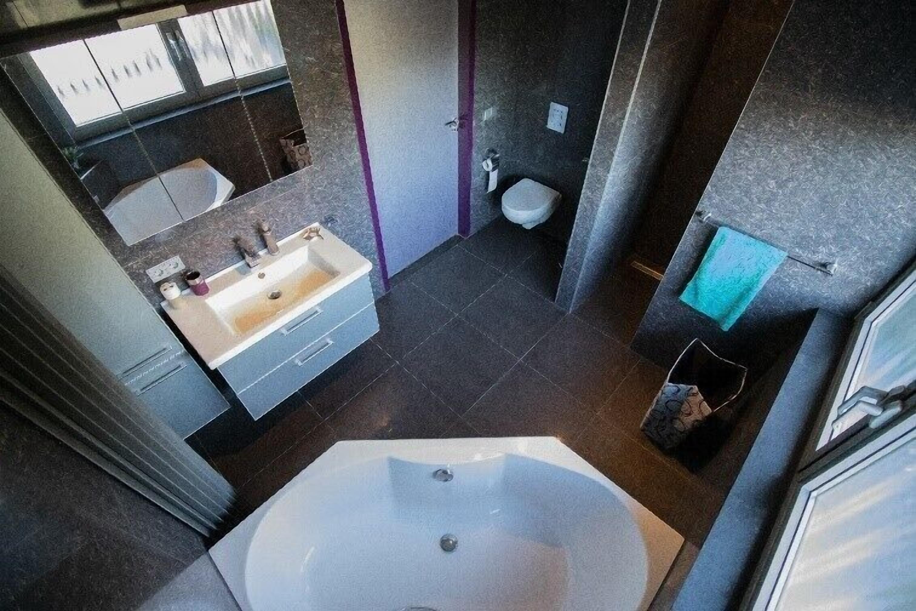 Un baño moderno con una bañera grande, un lavamanos y un inodoro.