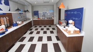 A modern kitchen with a checkered floor, wooden cabinets, and various appliances.