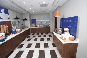 A modern kitchen with a checkered floor, wooden cabinets, and various appliances. - Holiday Inn Express McCook by IHG (McCook)