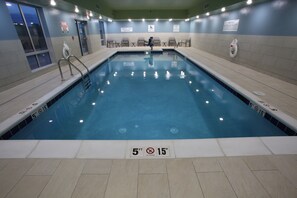 An indoor swimming pool with clear water, marked depth lines, and safety signs. - Holiday Inn Express McCook by IHG (McCook)
