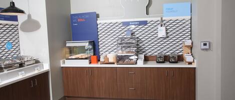 A modern kitchen with a bakery section, a coffee station, and a self-serve grab-and-go area.