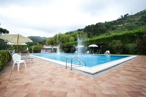 Piscine extérieure, parasols de plage, chaises longues