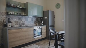 Una cocina compacta con armarios de madera, horno empotrado, cafetera y refrigerador.