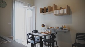 Un comedor con una mesa, sillas y una barra de desayuno con diversos alimentos y bebidas.