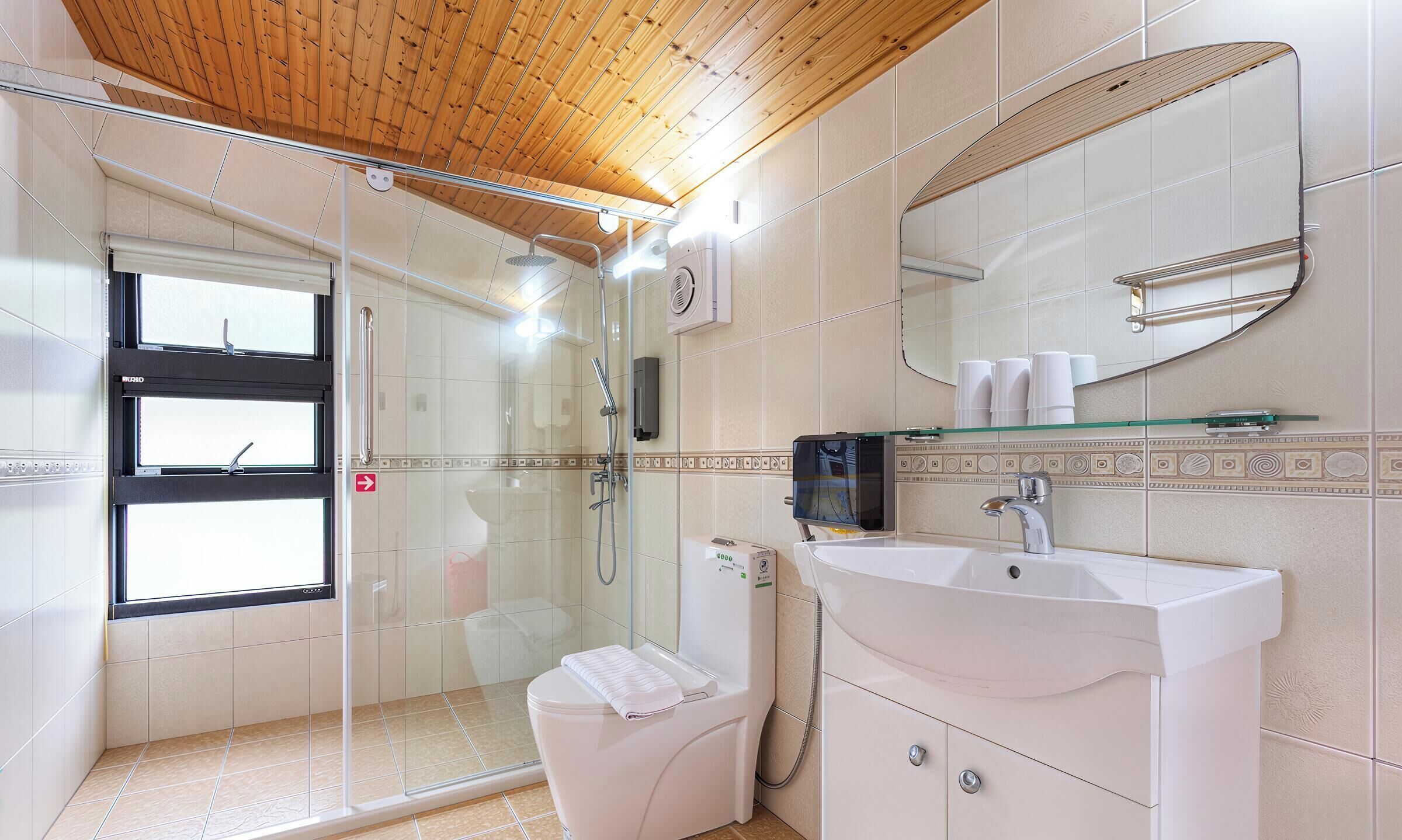 A modern bathroom with a glass shower enclosure, a toilet, a sink, and a mirror.