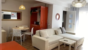 Una sala moderna con sofá, mesa de centro y comedor.