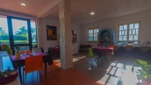 Un vaste espace de vie comprenant une grande fenêtre, une table à manger et plusieurs chaises.