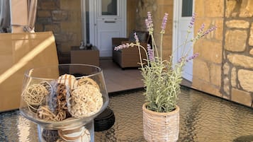 Una mesa de vidrio con adornos y una planta en una cesta de mimbre.