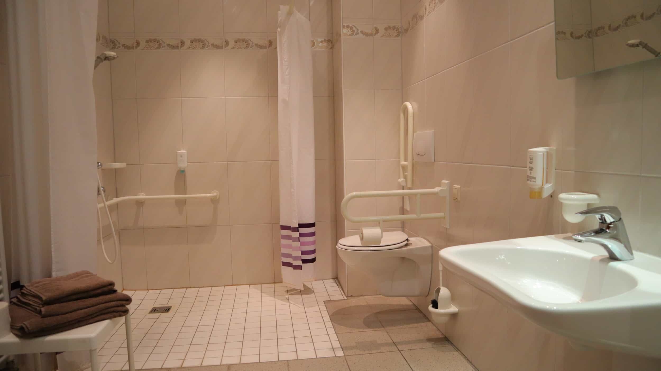 A bathroom with a shower, toilet, and sink.