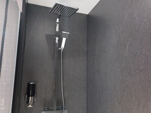 A modern shower with a square head and a handheld attachment.