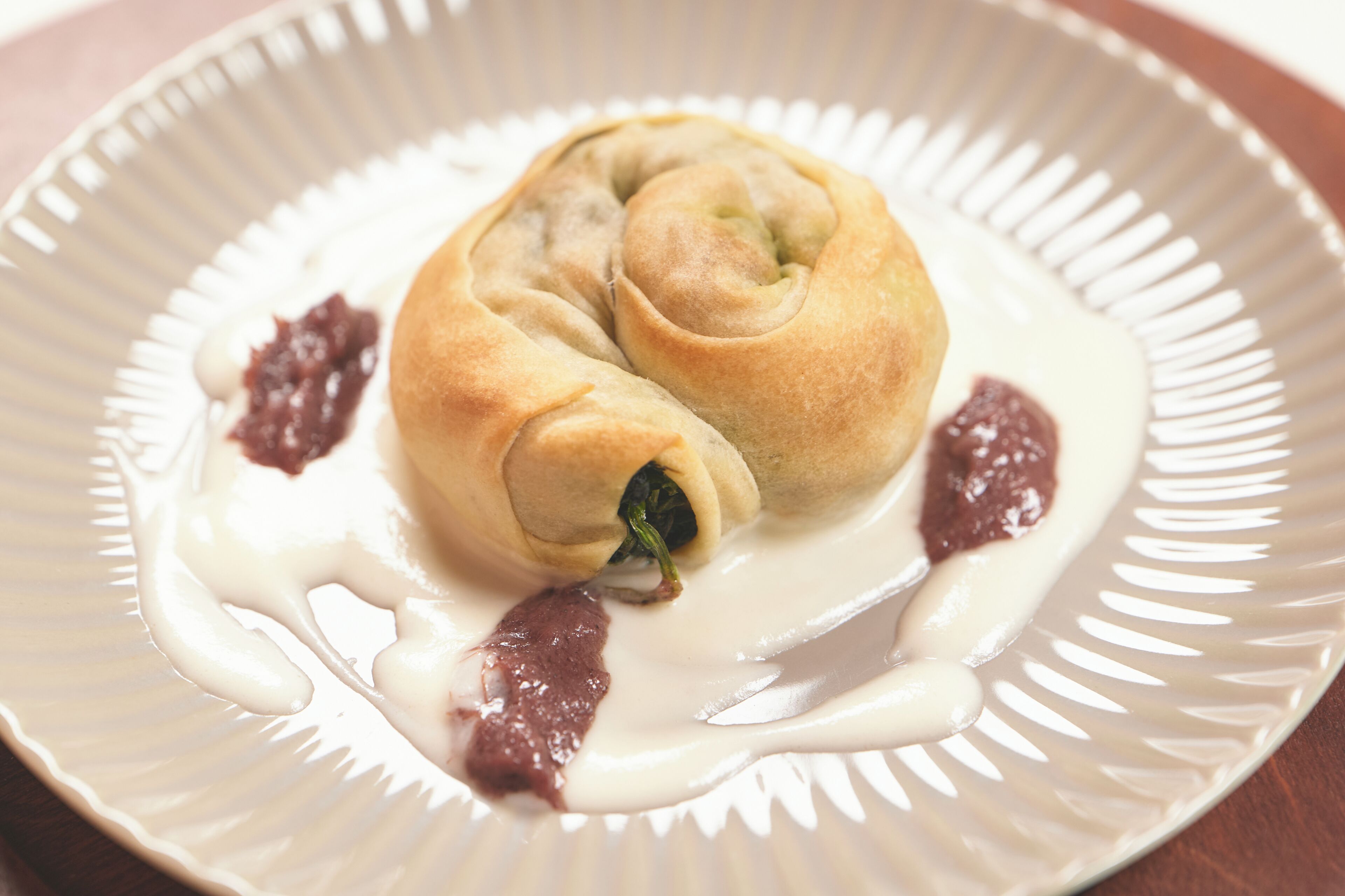 Une assiette avec une pâtisserie et une sauce.
