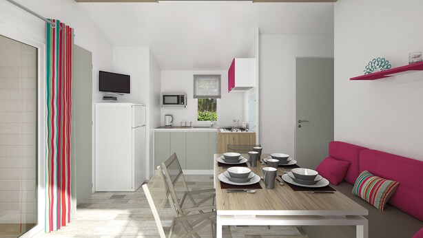 Une cuisine moderne avec un coin repas, un téléviseur fixé au-dessus du réfrigérateur et un canapé rose dans le salon.