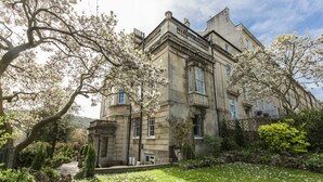 A historic building with a garden, stone facade, and multiple windows. - Grosvenor Villa (Bath)