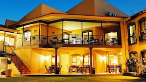 A two-story building with a balcony and outdoor seating area. - Benvenuto Hotel and Conference Centre (Randburg)