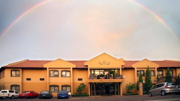 A hotel with a red-tiled roof, a central entrance, and a sign reading "Banrenio." - Benvenuto Hotel and Conference Centre (Randburg)